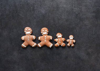 Yeni yıl planında mesaj için yer var. Maskeli zencefilli kurabiye ailesi. Noel arkaplanı zencefilli ekmek ve köknar..
