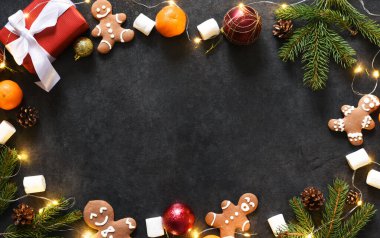 Noel arkaplanı zencefilli kurabiye ve hediyelerle dolu. Siyah bir arkaplanda Yeni Yıl planı.
