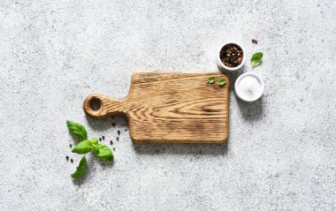 Açık beton zemin üzerinde baharatlarla kesme tahtası, metin için boşluk.