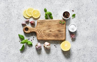 Açık beton bir zemin üzerinde baharat ve limon kesme tahtası, metin için boşluk.
