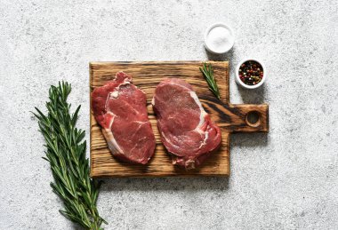 Ahşap bir tahtanın üzerinde ahşap bir ahşap denizciyle çiğ biftek pişirmek. Kopyalama alanı olan üst görünüm