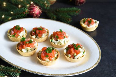 Yılbaşı masasında salata ve somonla doldurulmuş turta.