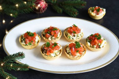 Yılbaşı masasında salata ve somonla doldurulmuş turta.