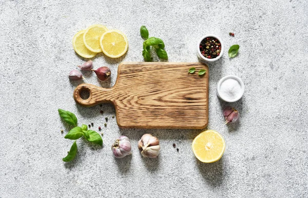 Açık beton bir zemin üzerinde baharat ve limon kesme tahtası, metin için boşluk.