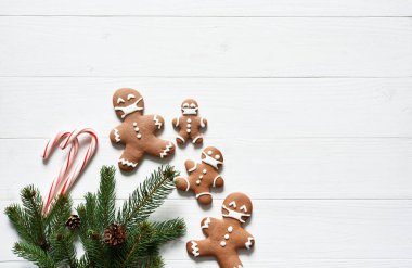 Yeni yıl konseptinde arka plan. Beyaz ahşap arka planda köknar ve zencefilli ekmek ile dekorasyon.