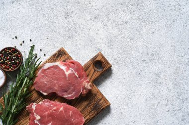 Ahşap bir tahtanın üzerinde ahşap bir ahşap denizciyle çiğ biftek pişirmek. Kopyalama alanı olan üst görünüm