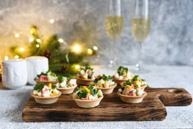 Yengeç çubuklu tart ve mısır ve şampanya Yeni yıl masasında bir bardakta.