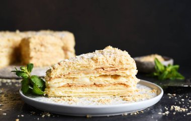 Koyu beton arka planda kremalı Napolyon pastası. Yatay odak.