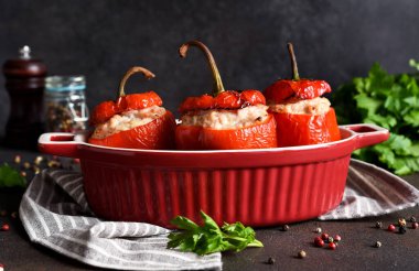 Doldurulmuş biberler et ve pirinçle pişirilmiş koyu beton arka planda.