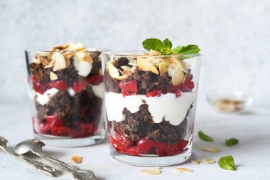 Hafif beton arka planda bir bardakta kara orman tatlısı. Geleneksel Alman tatlısı. Kara Orman keki..