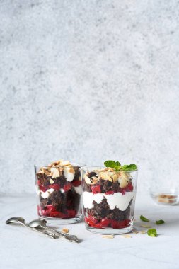 Hafif beton arka planda bir bardakta kara orman tatlısı. Geleneksel Alman tatlısı. Kara Orman keki..