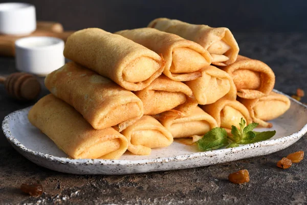 Koyu beton arka planda süzme peynirli ince krepler. Platformlar. Beyaz Rusya ve Ukrayna 'nın ulusal ve geleneksel yemekleri.