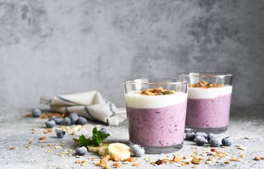 Beton arka planda yaban mersinli meyve püresi ve tahıl gevreği. Detoks menüsü. Diyet.