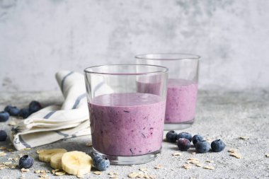 Beton arka planda yaban mersinli meyve püresi ve tahıl gevreği. Detoks menüsü. Diyet.