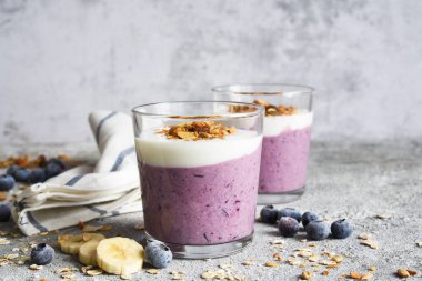 Beton arka planda yaban mersinli meyve püresi ve tahıl gevreği. Detoks menüsü. Diyet.