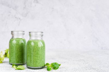 Detoks menüsü. Kavanozda beton bir arka planda ıspanaklı içecek..