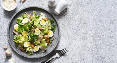 Beton tabakta ızgara tavuk ve parmesanlı geleneksel sezar salatası..