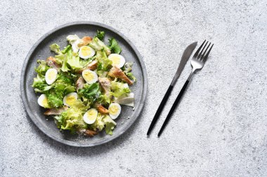 Beton tabakta ızgara tavuk ve parmesanlı geleneksel sezar salatası..