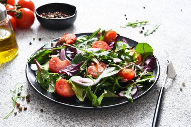Salatayı domates, soğan ve zeytinyağıyla siyah tabakta karıştır. Detoks menüsü. Keto diyeti..