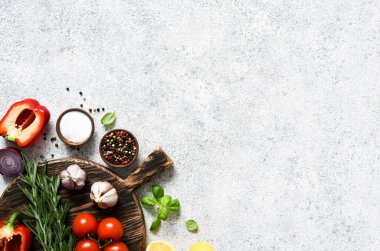 Lambada baharat ve sebze bulunan kahverengi kesim tahtası, beton mutfak masası. Düzen.