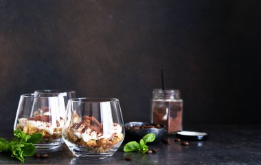 Koyu beton arka planda bir bardakta tiramisu tatlısı.
