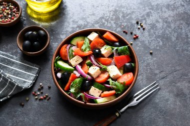 Beton arka planda beyaz peynir ve zeytinli klasik Yunan salatası..