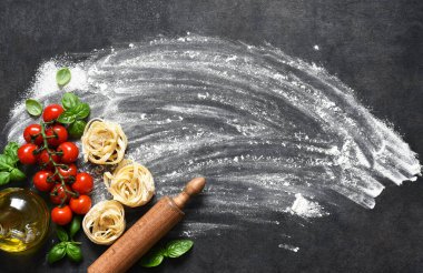 Un, merdane, domates ve fesleğen. Mutfak masasında makarna pişirme işlemi. Makarna yapmak için gerekli malzemeler.