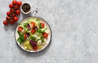Sebzeli yeşil salata ve çimento üzerine sos..