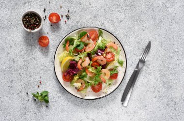 Salata, domates, ızgara karides, sos ve klemati mutfak masasında karıştırın. Yukarıdan bak. Somut gıda geçmişi.