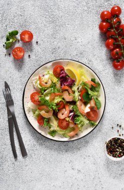 Salata, domates, ızgara karides, sos ve klemati mutfak masasında karıştırın. Yukarıdan bak. Somut gıda geçmişi.