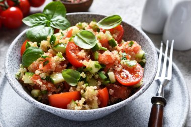 Domatesli hafif salata, salatalık ve zeytinyağı ve fesleğen ile beton arka planda..