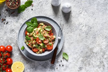 Domatesli hafif salata, salatalık ve zeytinyağı ve fesleğen ile beton arka planda..