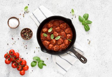 Hafif beton arka planda tavada domates soslu köfteler..