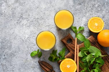 Gri beton arka planda taze sıkılmış portakal suyu..