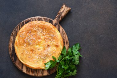Tahta bir tahtanın üzerinde sülüguni peyniri ve peynirli Khachapuri. Svehu görünümü.