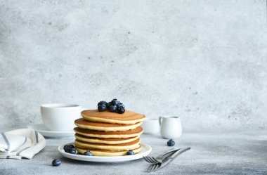 Beton zeminde kahvaltıda böğürtlen ve akçaağaç şurubuyla ev yapımı Amerikan krepleri..