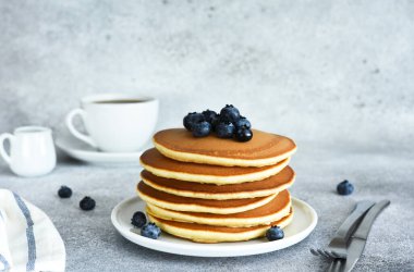 Beton zeminde kahvaltıda böğürtlen ve akçaağaç şurubuyla ev yapımı Amerikan krepleri..