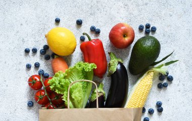 Yiyecek dolu kağıt torba. Süpermarketten alınmış bir poşette sebzeler. Tahtada reklamcılık. Yemek teslimatı.