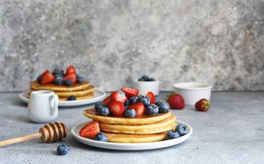 Mutfak masasında kahvaltıda çilekli ve yabanmersinli ev yapımı krepler..
