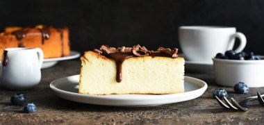 Cheesecake New York 'ta. Çikolata soslu cheesecake ve koyu beton arka planda bir fincan kahve..