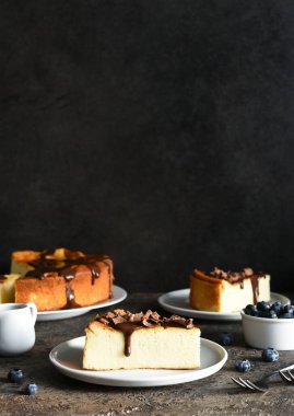 Cheesecake New York 'ta. Çikolata soslu cheesecake ve koyu beton arka planda bir fincan kahve..