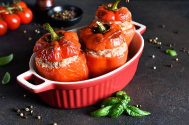 Doldurulmuş biber. Koyu beton bir arka planda pilav, et ve fesleğenle pişirilmiş biber..