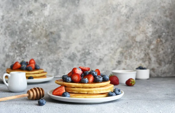 stock image Homemade pancakes with strawberries and blueberries for breakfast on the kitchen table.