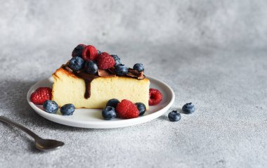 Çikolata soslu bir dilim cheesecake, böğürtlen ve bir fincan kahve....