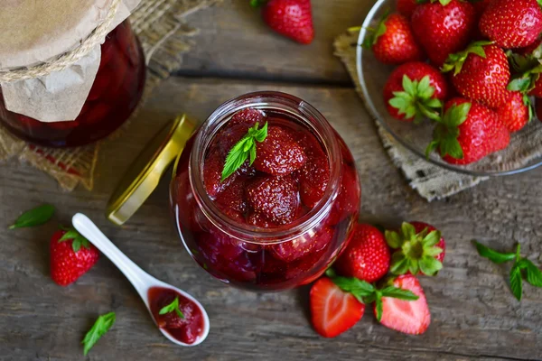Ahşap arka plan üzerinde kavanoza çilek reçeli