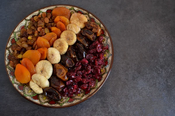 Dried fruit in a bowl on a dark background — Stock Photo, Image