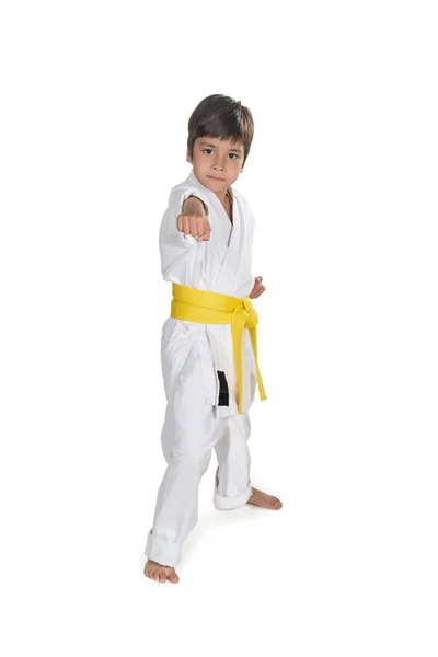 El muchacho se para en kimono blanco del karateka con un bel amarillo — Foto de Stock