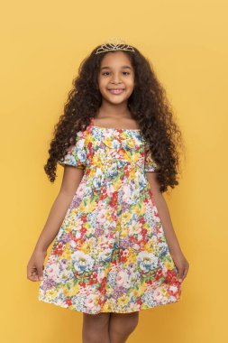 Koyu tenli, uzun kıvırcık saçlı, sarı arka planda taç takmış genç bir kızın yarım boy portresi.