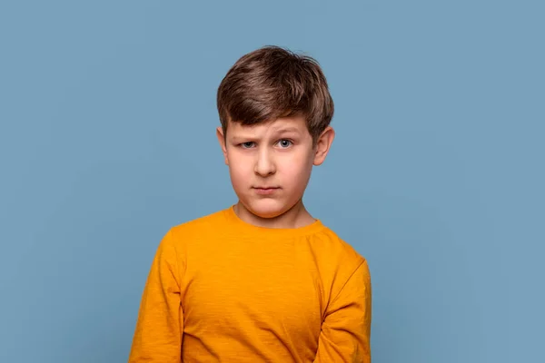 Studio Záběr Mladého Chlapce Žluté Košili Nespokojen Něčím Modrém Pozadí — Stock fotografie