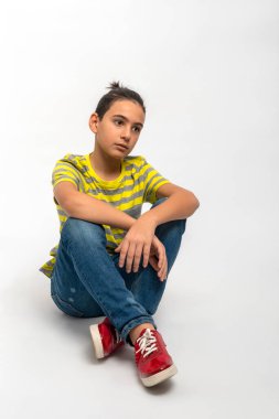 Genç adamın yerde otururken ve bir şey için üzülürken görüntüsü.